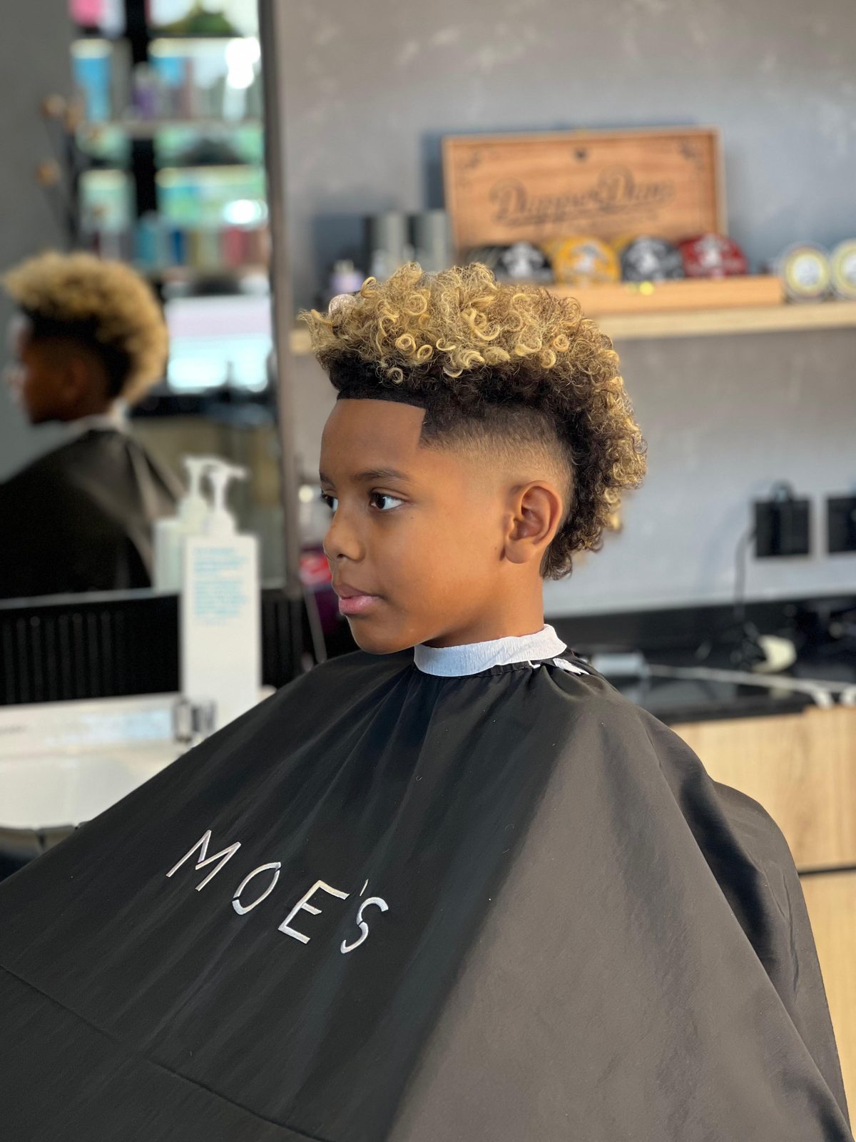 Kids cut — curls up top, taper below